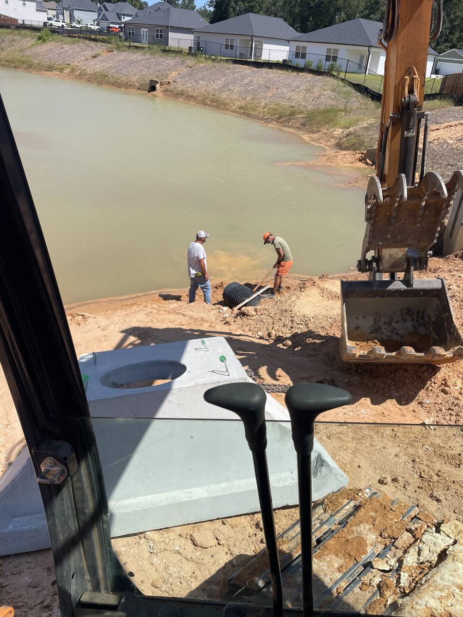 Setting a pond outlet structure, seen from the cab