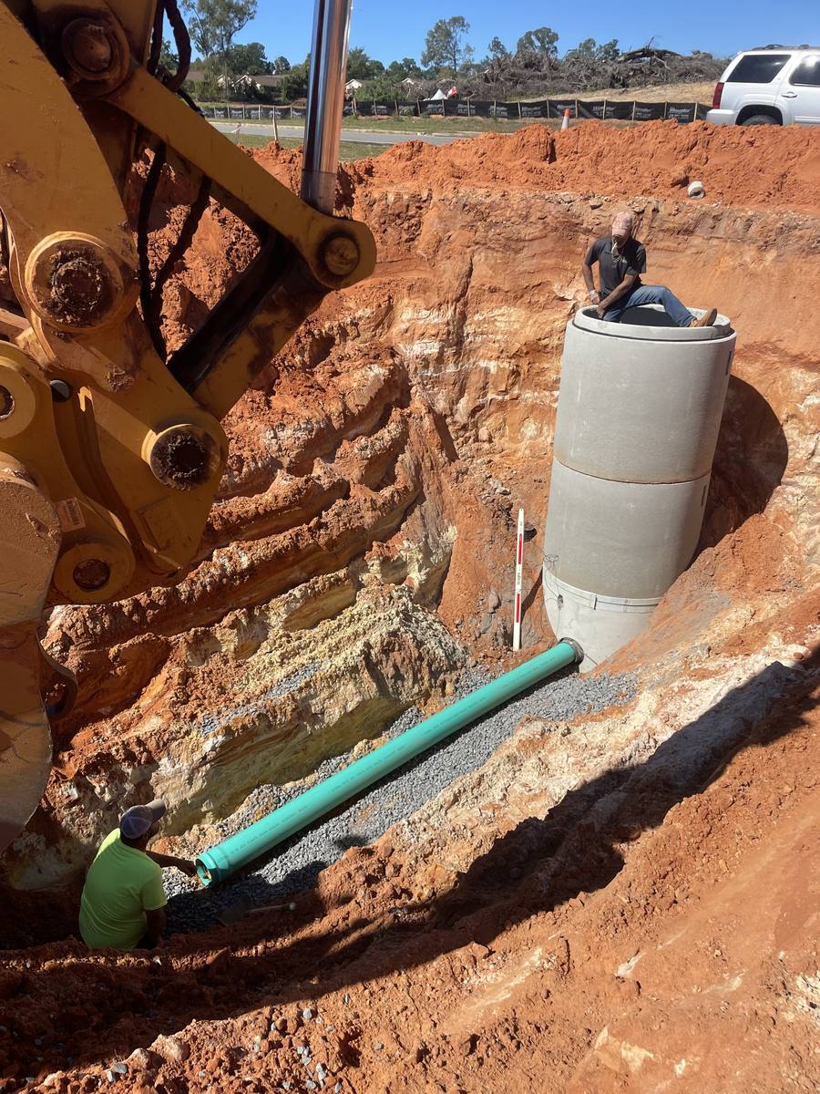 Manhole and sewer pipe set in a deep cut